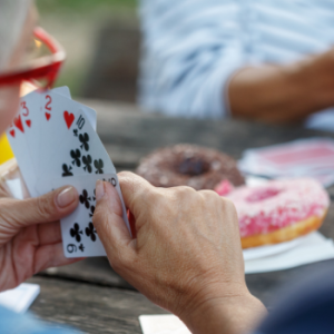 Adults gathered around a table playing Canasta during a social card game program at Worth Township.