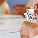 Adults gathered around a table playing Canasta during a social card game program at Worth Township.