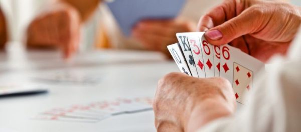 Adults gathered around a table playing Canasta during a social card game program at Worth Township.